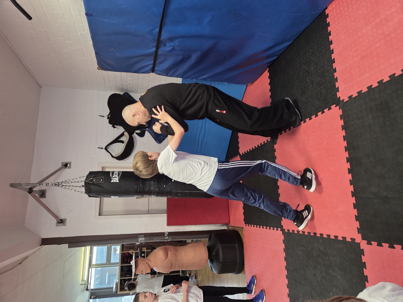 Jugendlicher beim Pratzentraining mit Trainer