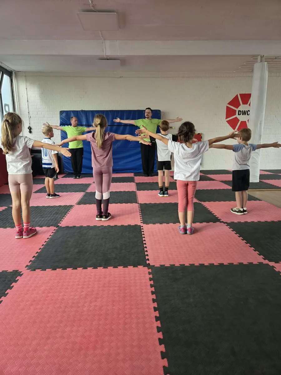 Eindrücke 9 Kindergruppe von hinten beim gemeinsamen Aufwärmen in der Trainingshalle