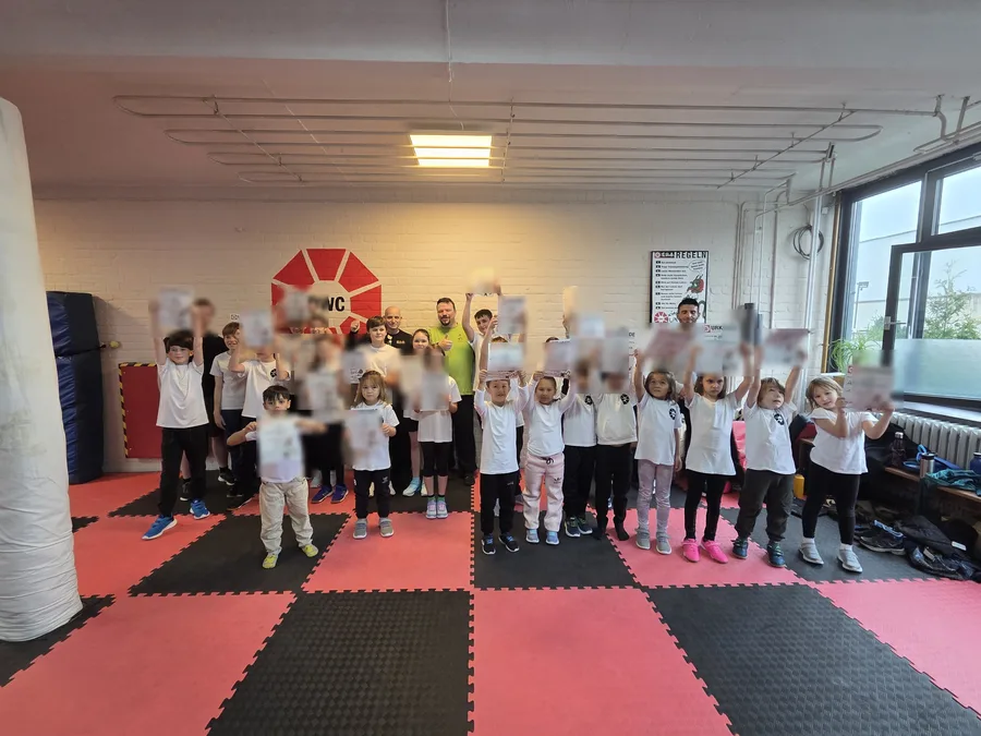 Eindrücke 2 Große Kindergruppe freut sich über bestandene Gürtelprüfung in der Trainingshalle